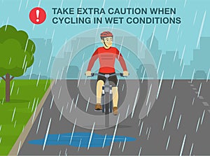 Take extra caution when cycling in wet conditions. Front view of a cyclist on the wet road in a rainy day