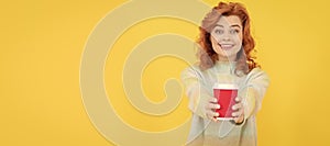 take this. happy red haired woman drink coffee. take away beverage. cheerful girl drinking tea. Woman isolated face