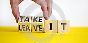 Take or leave it symbol. Businessman turns beautiful wooden cubes and changes words Leave it to Take it. Beautiful yellow table