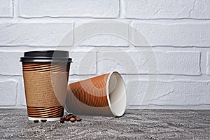 Take-out blank paper brown coffee cups with black covers, craft cup holders and beans
