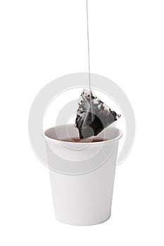 Take-out Cup with tea and tea bag over it. Isolated on white. Cardboard disposable Cup with tea bag on white background