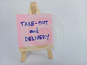 Take-out and delivery sign on a wood easel on a white background