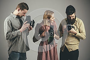 Take a picture, capture the magic. Retro style woman and men hold analog cameras. Paparazzi or photojournalists with