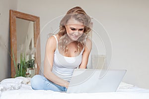 Take time to chill. Young happy woman using a laptop and having fun on the sofa at home