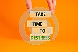 Take time to destress symbol. Concept words Take time to destress on wooden blocks. Beautiful orange table orange background.
