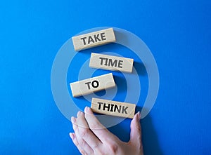 Take time to think symbol. Wooden blocks with words Take time to think. Businessman hand. Beautiful blue background. Business and