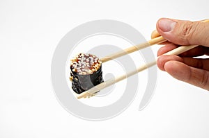 Take an unagi maki rolls with bamboo chopsticks on white background, asian food, japanese cuisine