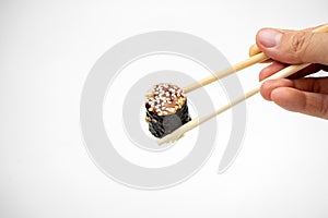 Take an unagi maki rolls with bamboo chopsticks on white background, asian food, japanese cuisine