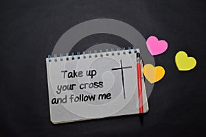 Take up Your Cross and Follow Me write on a book  on office desk. Christian faith concept