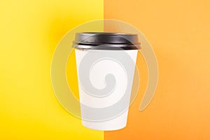 Takeaway coffee cup on orange and yellow background
