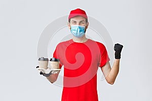 Takeaway, food and groceries delivery, covid-19 contactless orders concept. Cheerful courier in red uniform, gloves and