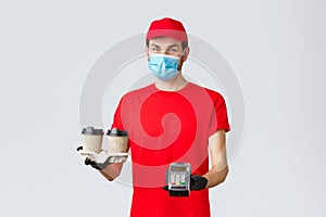 Takeaway, food and groceries delivery, covid-19 contactless orders concept. Pleasant courier in red uniform, gloves and
