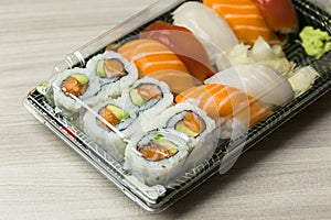 Takeaway food plastic containers for Sushi, Sashimi and Futomaki rolls. Fresh made Sushi set with salmon, prawns, wasabi and ging