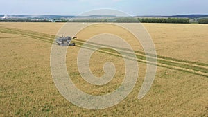 Taken from a drone, a red harvester drives through a field. Russia, Bashkortostan