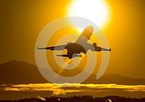 Takeoff of a passenger plane on the background of a sunset