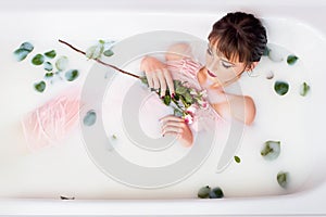 Takes a bath with milk and rose petals. Spa treatments for skin rejuvenation