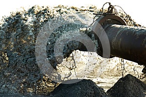 Taking advantage of the environment. Pipeline with polluted liquid gushing out of the pipe.