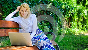 Taking advantages of free wi fi. Lady freelancer working in park. Woman with laptop works outdoor, green nature