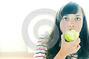 Taking a bite of a green apple