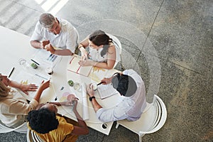 Taking business ideas to new heights. High angle shot of a team of businesspeople having a meeting around a table in