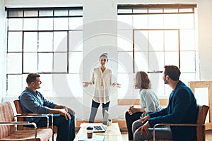 Taking business to the top with efficient teamwork. a group of young businesspeople having a meeting in a modern office.