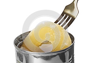 Taking canned pineapple ring from tin with fork on background, closeup