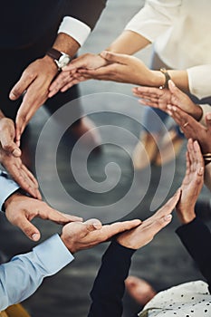 Taking care of business together. High angle shot of a group of unidentifiable businesspeople forming a circle with