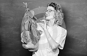 taking care of flowers. happy student girl with plant at blackboard. teacher woman in glasses at biology lesson. tree of