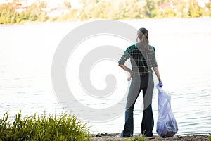 Taking care of our planet, fighting plastic garbage in nature. A young female volunteer