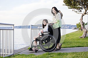 Taking care of sister in wheelchair by beach