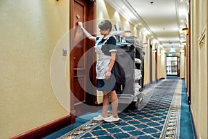 Taking care of your comfort. Full-length shot of hotel maid in uniform knocking on the door for room service while