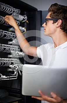 Taking care of your network needs. A computer technician fixing a server.