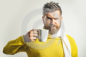 Taking coffee break. Stylish man drinks cup of cappuccino. Handsome bearded male with mug of tea.