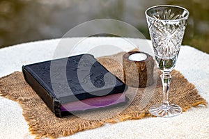 Taking Communion. Cup of glass with red wine, bread and Holy Bib