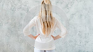 Taking decision blonde woman hands hips backview