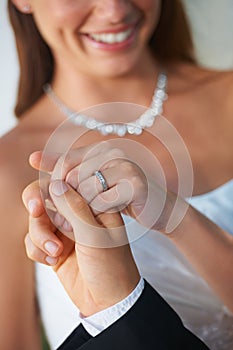Taking the hand of his wife. Closeup of a groom leading his bride out of the chapel - Focus on Wedding Ring.