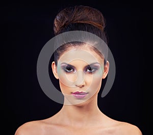Taking makeup up a notch. Studio portrait of a beautiful young woman wearing colorful makeup.