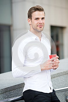 Taking moment enjoy day. Man well groomed white shirt drinks coffee urban background. Businessman relaxing with coffee