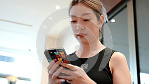 Taking a moment to unwind, a tourist woman sits comfortably on a coach and types on her phone.