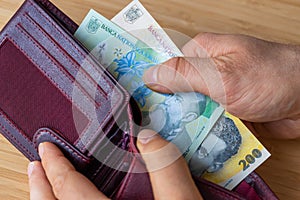 Taking money out of wallet, Romanian lei, Financial and economic concept, Household situation, inflation, rising prices in Romania