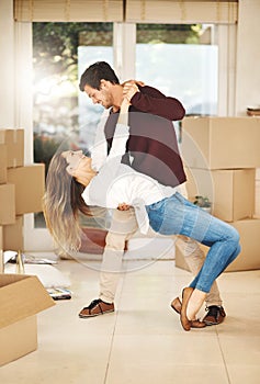 Taking that next step together. Full length shot of an affectionate young couple dancing while moving into a new home.