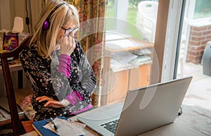 Woman on laptop,working from home, watching a webinar photo