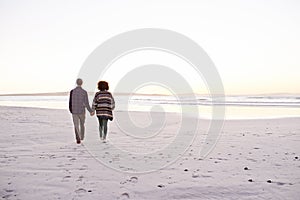 Taking it one step at a time. a young couple enjoying a walk on the beach.