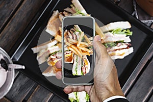 Taking photo of club sandwich, top view by mobile smart phone