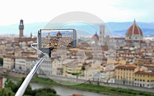 Taking photos with smart phone and selfie stick in Florence in I