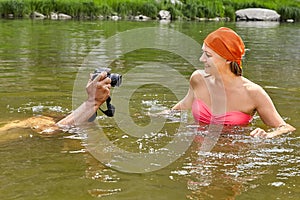 Taking pictures of smiling woman in water