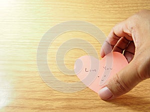 Taking pink sticky paper notes by hand, telling love you