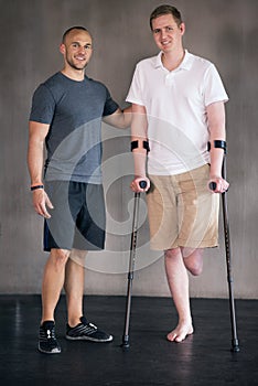 Taking recovery one step at time. Studio shot of a young amputee training in a gym.