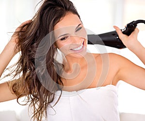 Taking the time to care for her hair properly. Closeup shot of a beautiful woman drying her hair with a hairdryer.