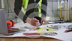 Taking video details working architect at construction site he make some measurements for construction plan using laptop
